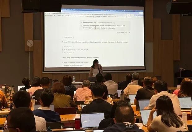 Lecture-style corporate training session with laptops